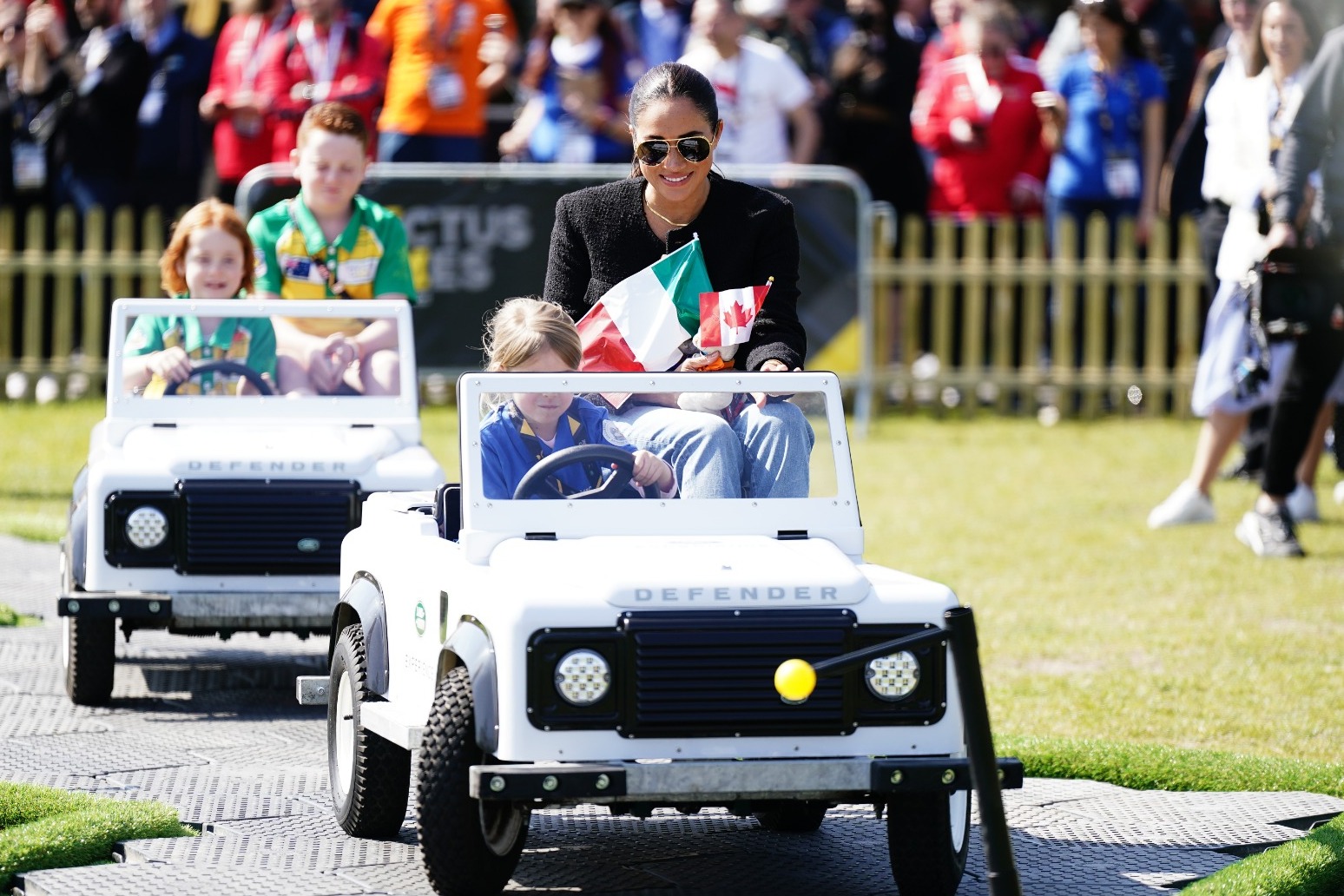 Harry and Meghan go for a spin in mini cars driven by children at Invictus Games 